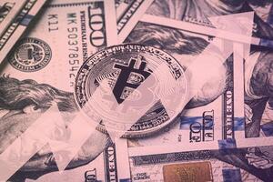 Dollar bills and metal souvenir bitcoin. The concept of electronic money and commerce. photo