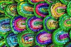 Beautiful multi-colored sequins shimmering in the light in the form of a peacock tail. Abstract background. photo