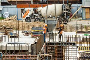 RUSSIA, KALUGA - AUGUST 15, 2022 Workers assembling the frame of a building from rebar. photo