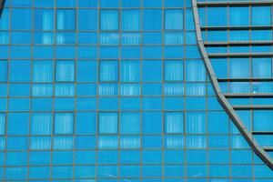 Fragment of a modern office building. Abstract geometric background. Part of a skyscraper with glass windows. photo