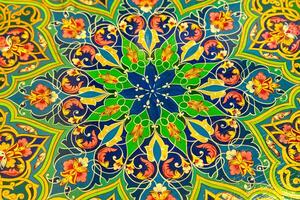 Colorful vintage oriental ornament painted on the tabletop. Abstract background. photo