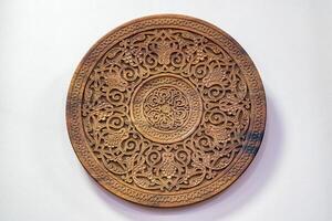 Fragment of an ancient carved wooden round plate. Ornate. photo