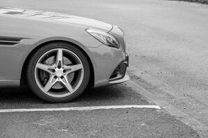 partial shot of a sports car in gray on asphalt photo