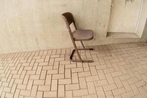 chair on paving stones in front of house wall photo