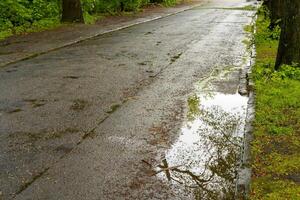 Poor asphalt road with potholes after the rain photo