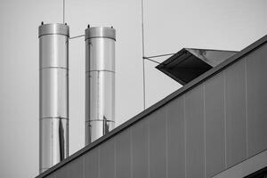 grande inoxidable acero chimeneas en el techo de un industrial edificio foto