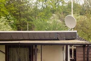 satélite antena en el techo de un jardín cobertizo foto