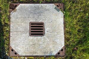 concrete manhole cover in meadow photo