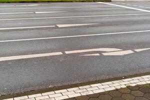 directional arrows on a wet asphalt road photo