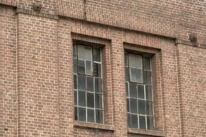 detalles de un antiguo industrial edificio, ladrillo pared y ventanas, aprox. 100 años antiguo foto