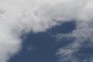 Cloudscape scenery, overcast weather above dark blue sky. Storm clouds floating in a rainy dull day with natural light. White and grey scenic environment background. Nature view. photo