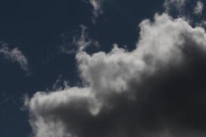Cloudscape scenery, overcast weather above dark blue sky. Storm clouds floating in a rainy dull day with natural light. White and grey scenic environment background. Nature view. photo