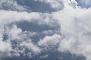 Cloudscape scenery, overcast weather above dark blue sky. Storm clouds floating in a rainy dull day with natural light. White and grey scenic environment background. Nature view. photo