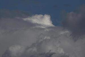 Cloudscape scenery, overcast weather above dark blue sky. Storm clouds floating in a rainy dull day with natural light. White and grey scenic environment background. Nature view. photo