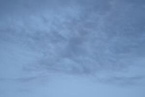 Cloudscape scenery, overcast weather above dark blue sky. Storm clouds floating in a rainy dull day with natural light. White and grey scenic environment background. Nature view. photo