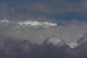 Cloudscape scenery, overcast weather above dark blue sky. Storm clouds floating in a rainy dull day with natural light. White and grey scenic environment background. Nature view. photo