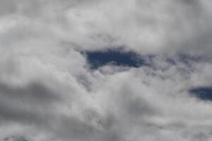 Cloudscape scenery, overcast weather above dark blue sky. Storm clouds floating in a rainy dull day with natural light. White and grey scenic environment background. Nature view. photo