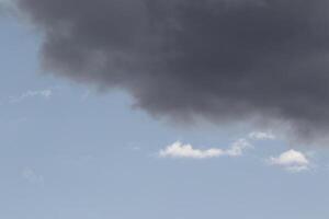 Cloudscape scenery, overcast weather above dark blue sky. Storm clouds floating in a rainy dull day with natural light. White and grey scenic environment background. Nature view. photo