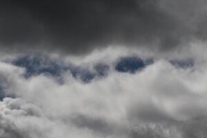 Cloudscape scenery, overcast weather above dark blue sky. Storm clouds floating in a rainy dull day with natural light. White and grey scenic environment background. Nature view. photo