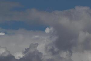 Cloudscape scenery, overcast weather above dark blue sky. Storm clouds floating in a rainy dull day with natural light. White and grey scenic environment background. Nature view. photo