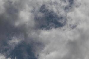 Cloudscape scenery, overcast weather above dark blue sky. Storm clouds floating in a rainy dull day with natural light. White and grey scenic environment background. Nature view. photo