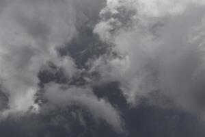 Cloudscape scenery, overcast weather above dark blue sky. Storm clouds floating in a rainy dull day with natural light. White and grey scenic environment background. Nature view. photo