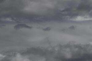Cloudscape scenery, overcast weather above dark blue sky. Storm clouds floating in a rainy dull day with natural light. White and grey scenic environment background. Nature view. photo
