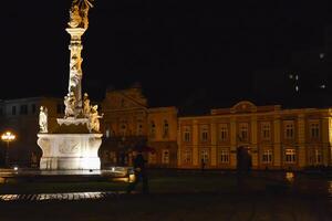 personas caminando en un lluvioso día en el calle. Unión cuadrado a noche, timisoara foto