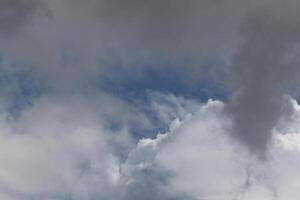 Cloudscape scenery, overcast weather above dark blue sky. Storm clouds floating in a rainy dull day with natural light. White and grey scenic environment background. Nature view. photo