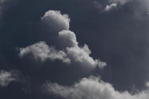 Cloudscape scenery, overcast weather above dark blue sky. Storm clouds floating in a rainy dull day with natural light. White and grey scenic environment background. Nature view. photo