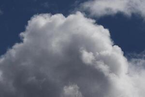 Cloudscape scenery, overcast weather above dark blue sky. Storm clouds floating in a rainy dull day with natural light. White and grey scenic environment background. Nature view. photo