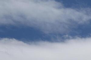 Cloudscape scenery, overcast weather above dark blue sky. Storm clouds floating in a rainy dull day with natural light. White and grey scenic environment background. Nature view. photo