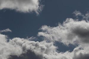Cloudscape scenery, overcast weather above dark blue sky. Storm clouds floating in a rainy dull day with natural light. White and grey scenic environment background. Nature view. photo