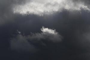 Cloudscape scenery, overcast weather above dark blue sky. Storm clouds floating in a rainy dull day with natural light. White and grey scenic environment background. Nature view. photo