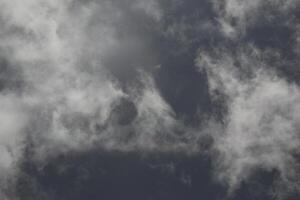 Cloudscape scenery, overcast weather above dark blue sky. Storm clouds floating in a rainy dull day with natural light. White and grey scenic environment background. Nature view. photo