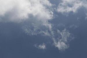 Cloudscape scenery, overcast weather above dark blue sky. Storm clouds floating in a rainy dull day with natural light. White and grey scenic environment background. Nature view. photo