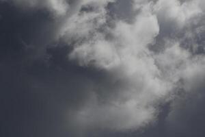 Cloudscape scenery, overcast weather above dark blue sky. Storm clouds floating in a rainy dull day with natural light. White and grey scenic environment background. Nature view. photo