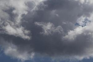 Cloudscape scenery, overcast weather above dark blue sky. Storm clouds floating in a rainy dull day with natural light. White and grey scenic environment background. Nature view. photo