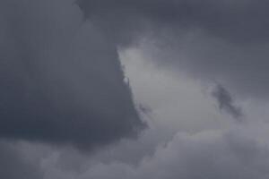 Cloudscape scenery, overcast weather above dark blue sky. Storm clouds floating in a rainy dull day with natural light. White and grey scenic environment background. Nature view. photo