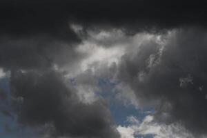 Cloudscape scenery, overcast weather above dark blue sky. Storm clouds floating in a rainy dull day with natural light. White and grey scenic environment background. Nature view. photo