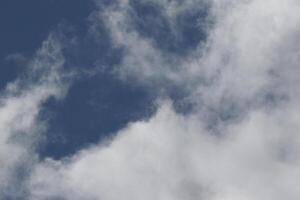 Cloudscape scenery, overcast weather above dark blue sky. Storm clouds floating in a rainy dull day with natural light. White and grey scenic environment background. Nature view. photo