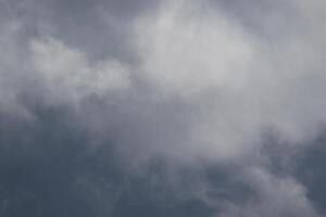 Cloudscape scenery, overcast weather above dark blue sky. Storm clouds floating in a rainy dull day with natural light. White and grey scenic environment background. Nature view. photo