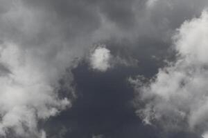 Cloudscape scenery, overcast weather above dark blue sky. Storm clouds floating in a rainy dull day with natural light. White and grey scenic environment background. Nature view. photo