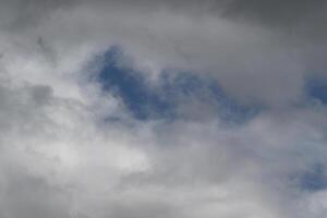Cloudscape scenery, overcast weather above dark blue sky. Storm clouds floating in a rainy dull day with natural light. White and grey scenic environment background. Nature view. photo