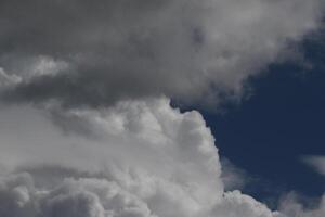 Cloudscape scenery, overcast weather above dark blue sky. Storm clouds floating in a rainy dull day with natural light. White and grey scenic environment background. Nature view. photo