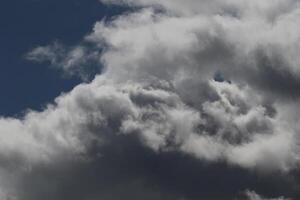 Cloudscape scenery, overcast weather above dark blue sky. Storm clouds floating in a rainy dull day with natural light. White and grey scenic environment background. Nature view. photo