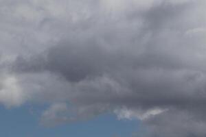 Cloudscape scenery, overcast weather above dark blue sky. Storm clouds floating in a rainy dull day with natural light. White and grey scenic environment background. Nature view. photo