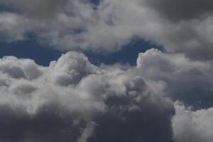 Cloudscape escenario, nublado clima encima oscuro azul cielo. tormenta nubes flotante en un lluvioso aburrido día con natural ligero. blanco y gris escénico ambiente antecedentes. naturaleza vista. foto