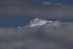 Cloudscape escenario, nublado clima encima oscuro azul cielo. tormenta nubes flotante en un lluvioso aburrido día con natural ligero. blanco y gris escénico ambiente antecedentes. naturaleza vista. foto