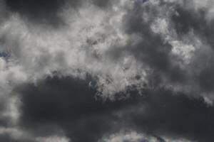 Cloudscape scenery, overcast weather above dark blue sky. Storm clouds floating in a rainy dull day with natural light. White and grey scenic environment background. Nature view. photo